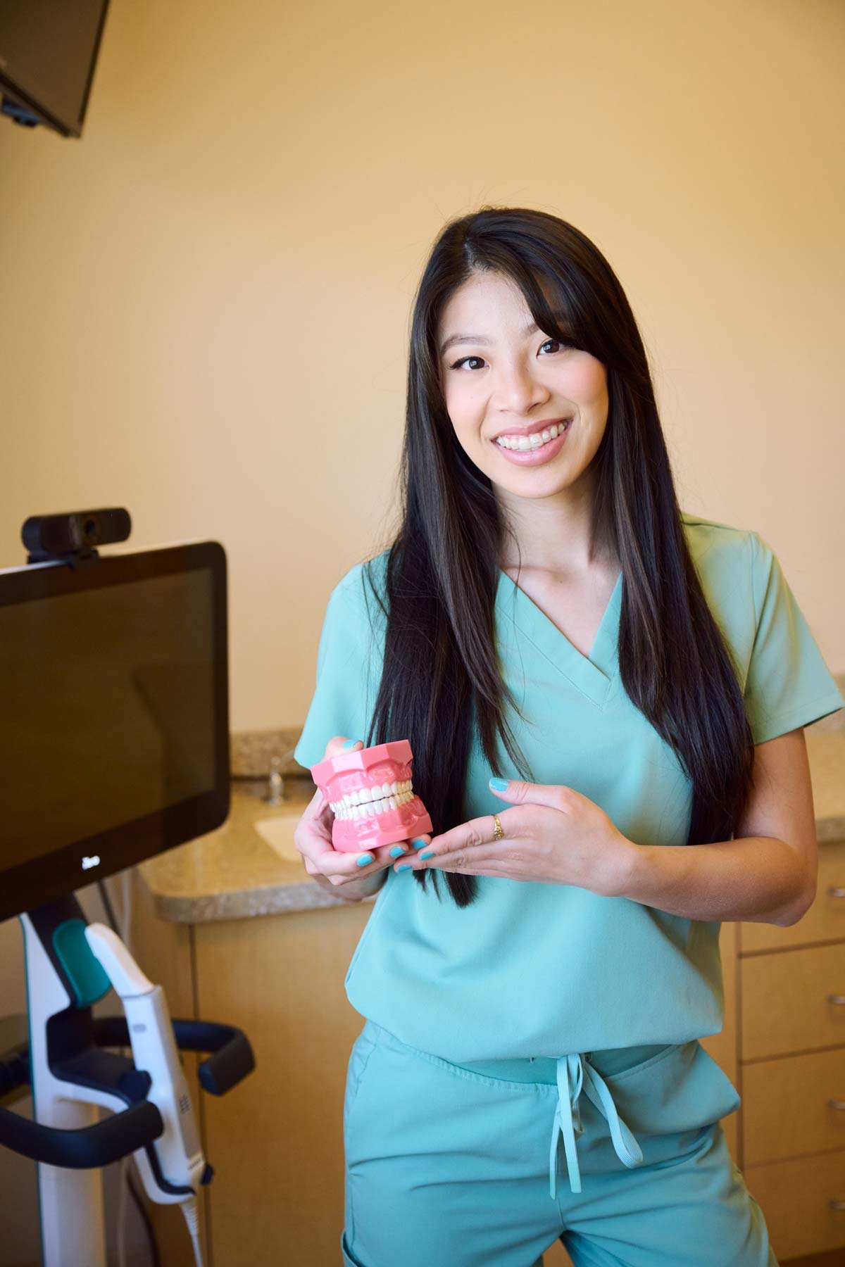 Dr. Thu Hoang in a treatment room beside the digital scanner